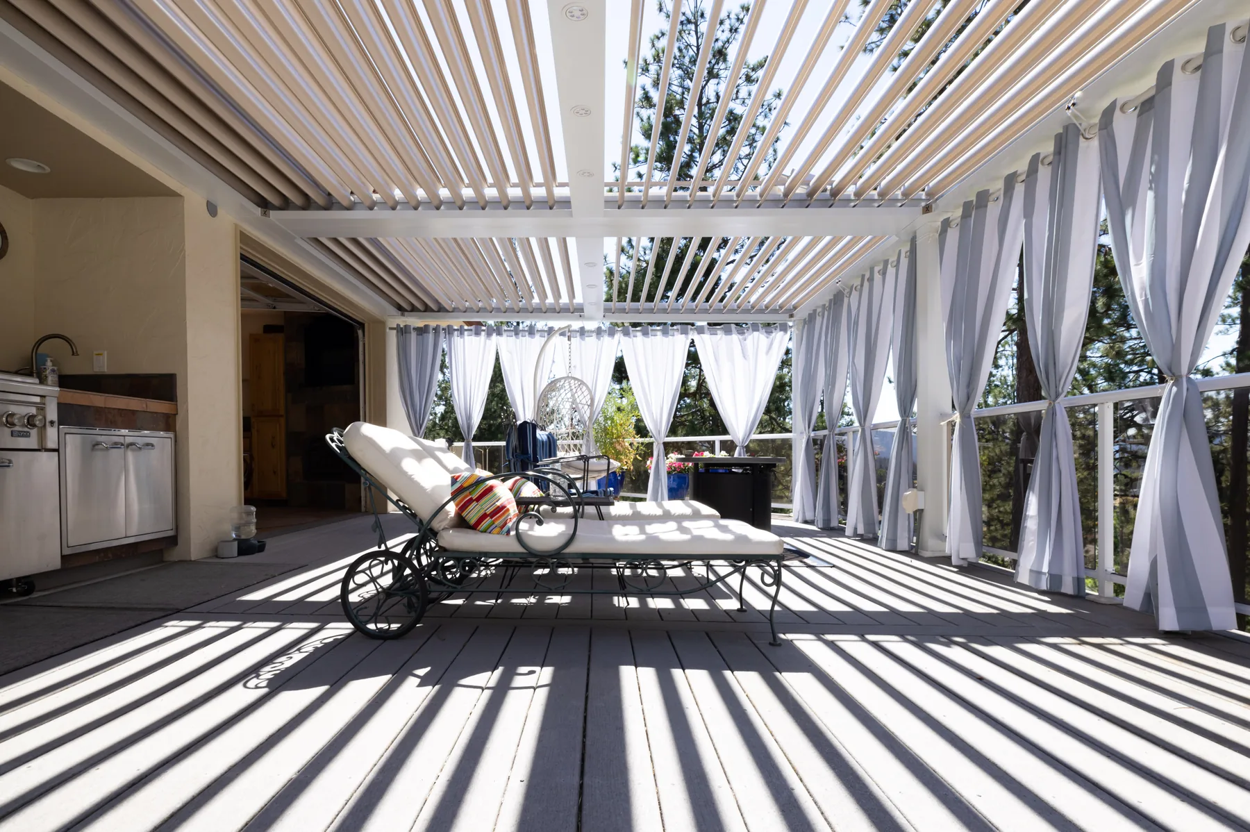 Pergola casting louvered shade across a patio