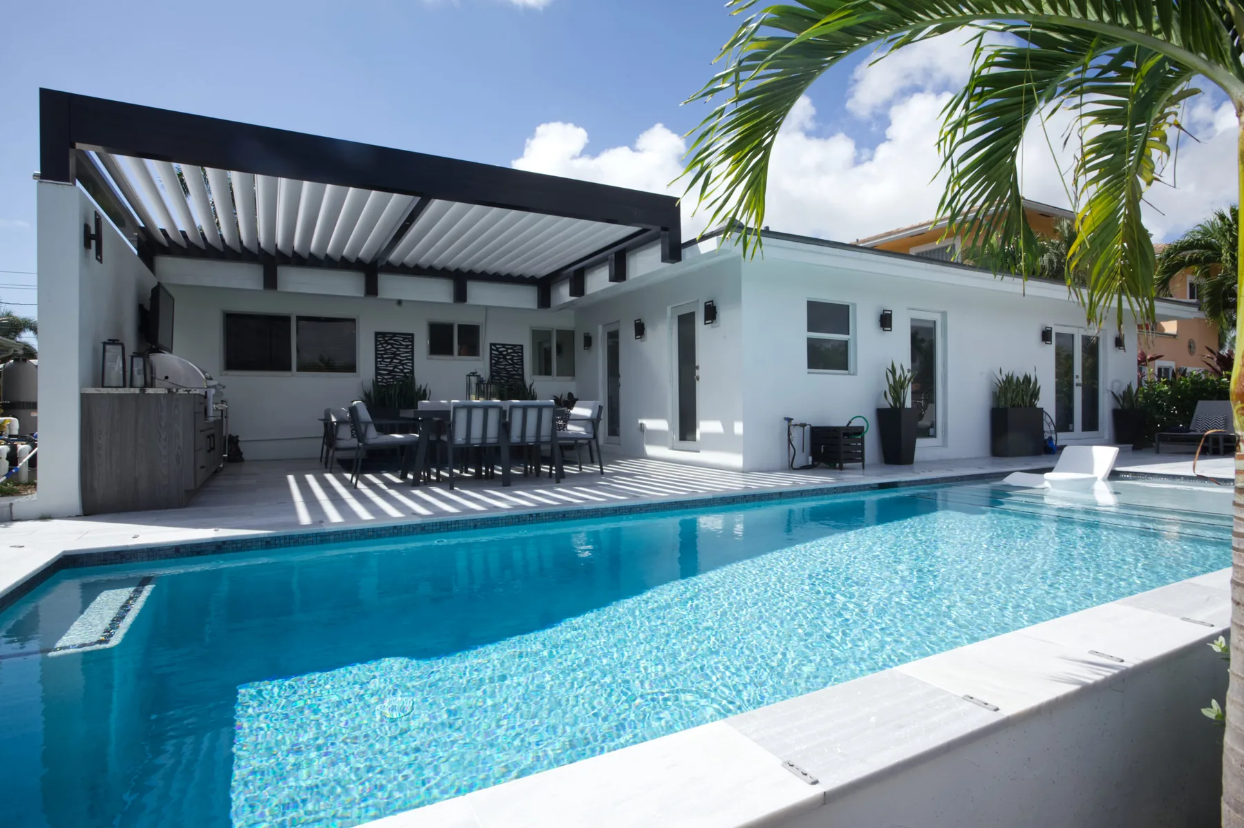 Modern poolside pergola with palm trees