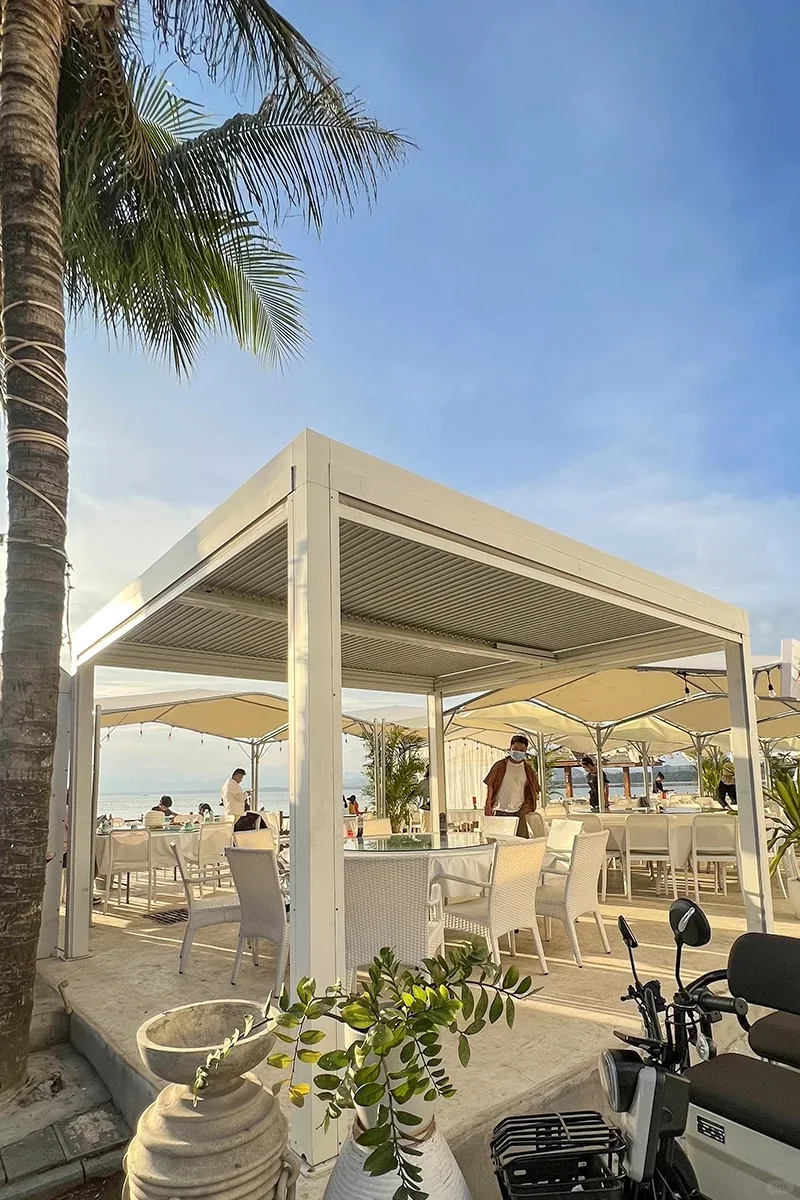 Beach club pergola shade structure beside palm trees