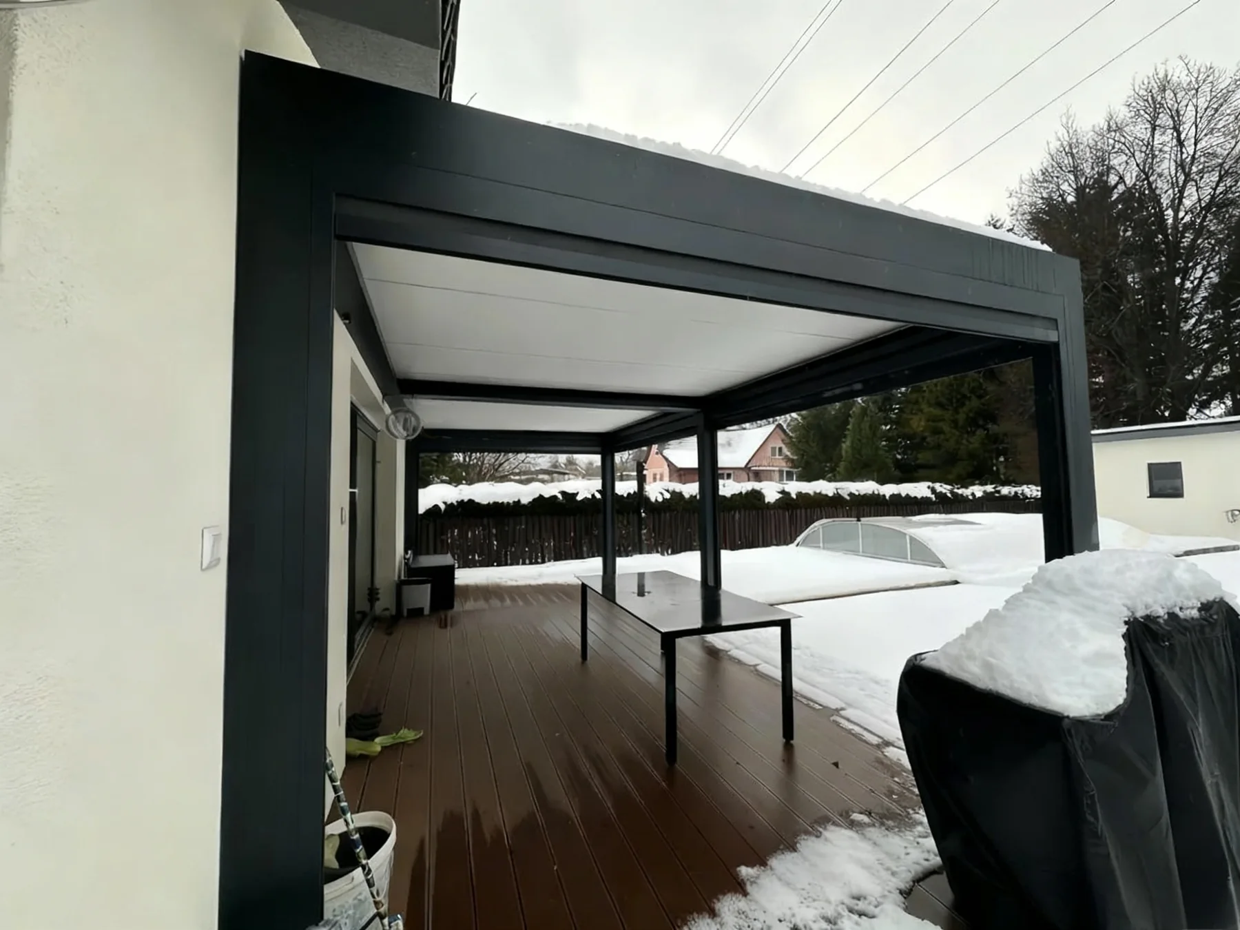 Cold-climate patio pergola with snow around the deck